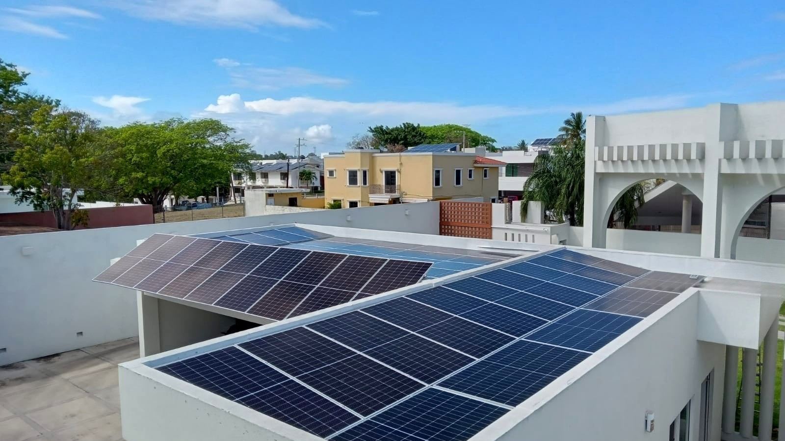 Paneles solares sobre una azotea residencial con cielo despejado, instalados por Ecolux