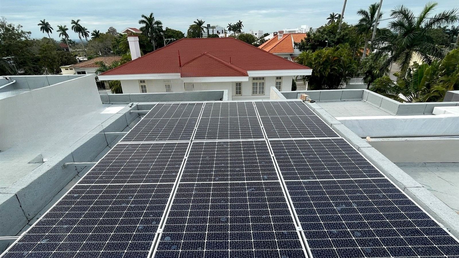Paneles solares sobre azotea plana con vista a las casas de la zona, instalados por Ecolux