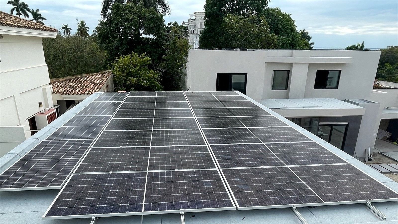 Planta solar residencial sobre azotea con vecindario arbolado, instalada por Ecolux