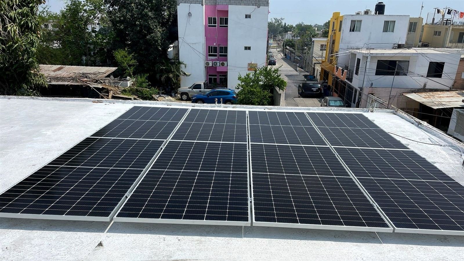 Paneles solares sobre azotea blanca en una colonia de Tampico, instalados por Ecolux